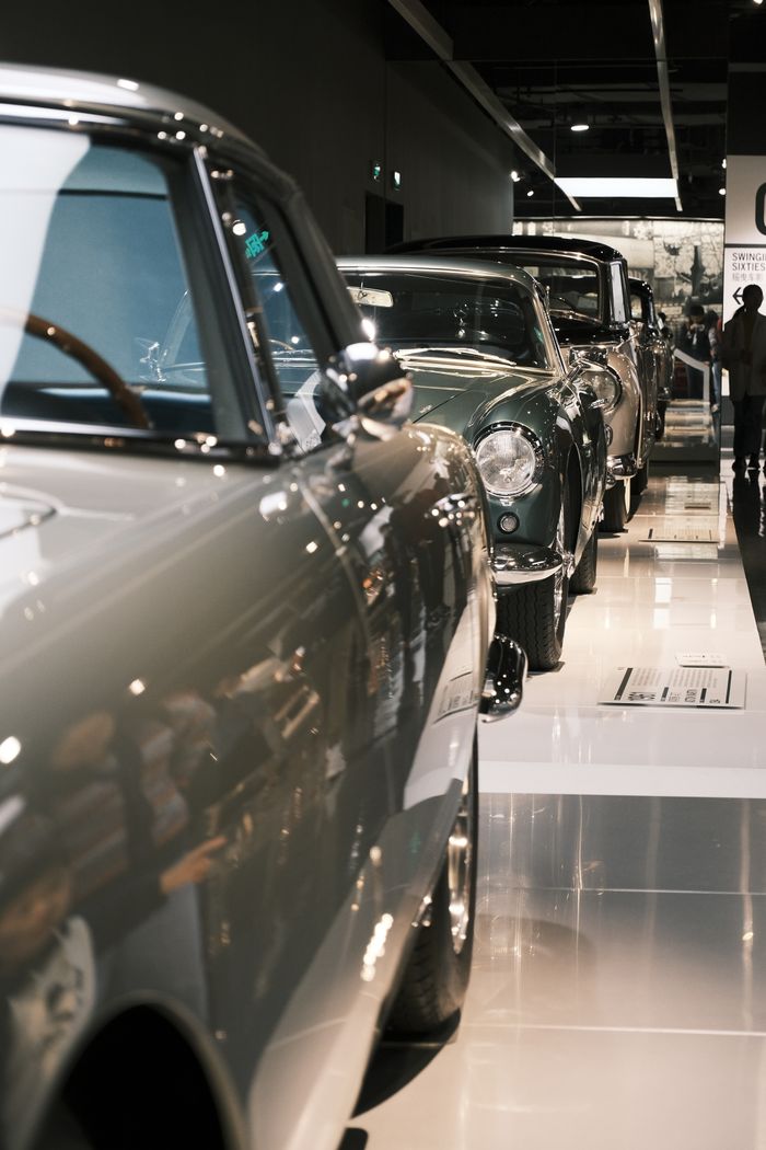 About A line of vintage cars showcased in an elegant indoor showroom capturing automotive nostalgia.