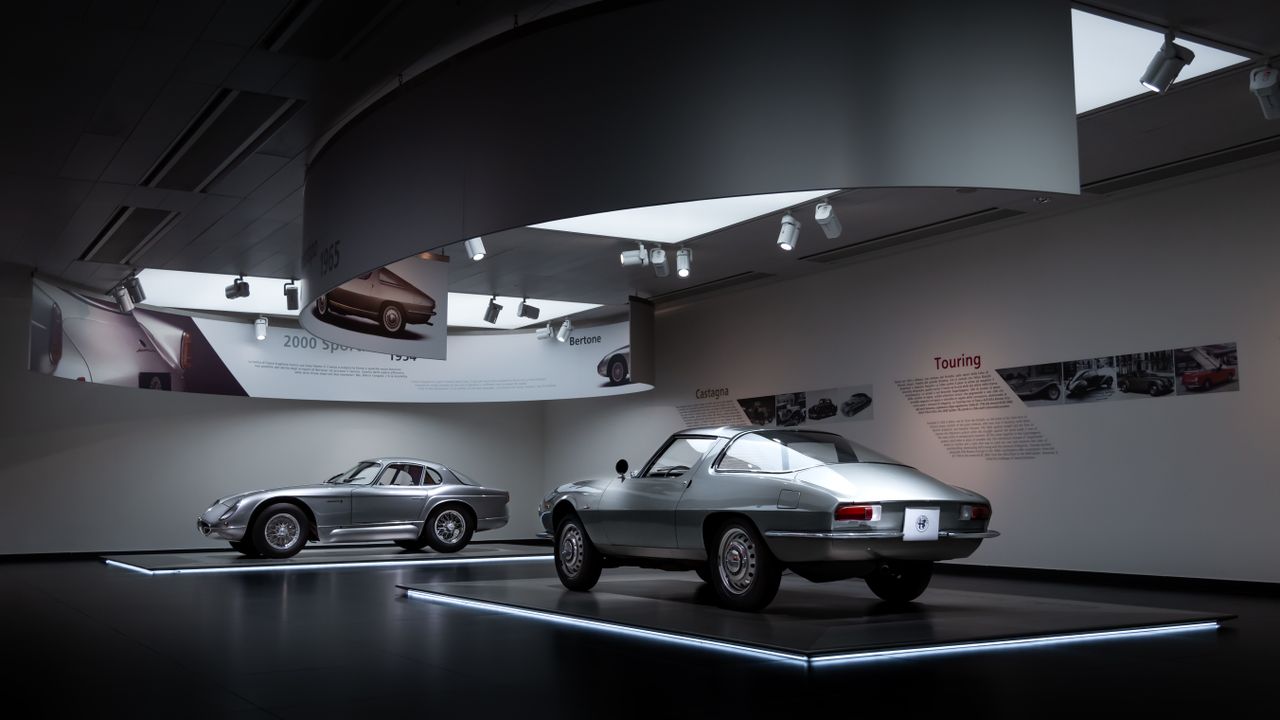Services Showcasing vintage Alfa Romeo cars in an elegant museum exhibit.